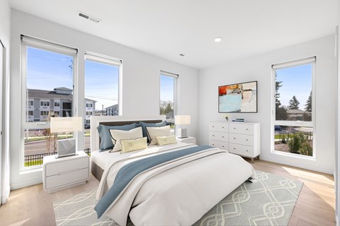 a bedroom with a bed and three windows