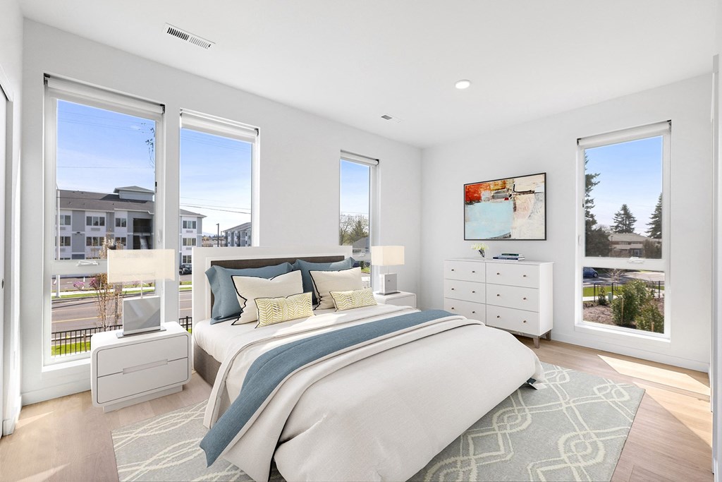 a bedroom with a bed and three windows