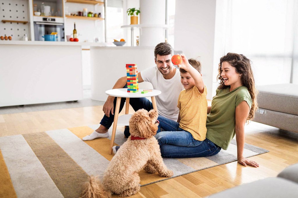 Family playing with toys and dog on floor