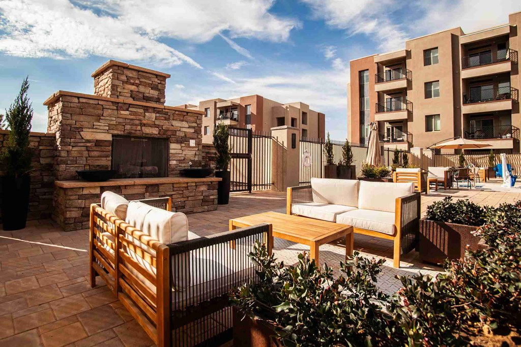 A patio with a fireplace and seating area.