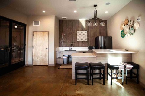 a large kitchen with a center island and a bar with chairs
