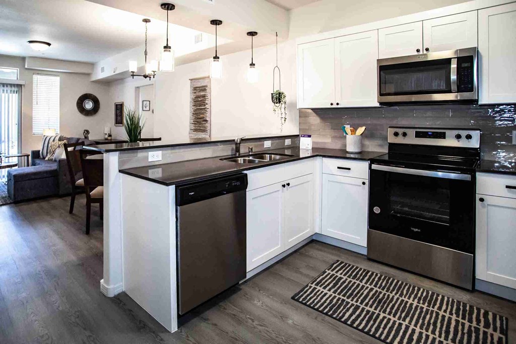 Modern kitchen with white cabinets and stainless steel appliances.