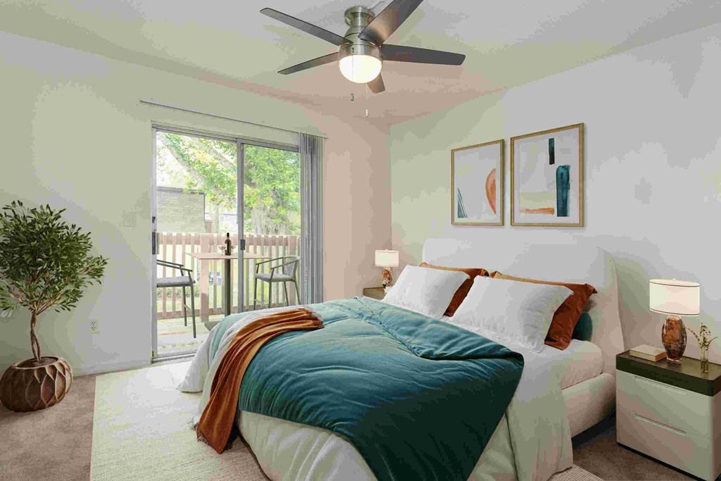 A bedroom with a bed, nightstand, and a ceiling fan.