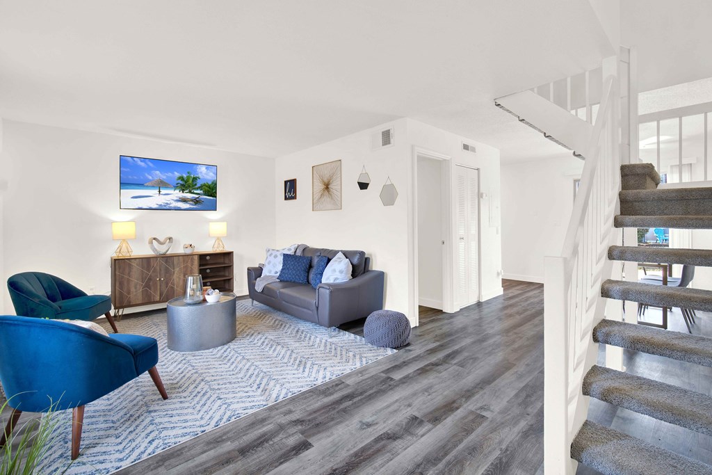 A living room with a blue chair and a grey couch.