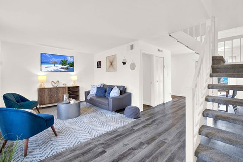 A living room with a blue chair and a grey couch.
