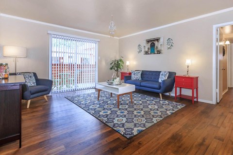A living room with a blue couch and a white coffee table.