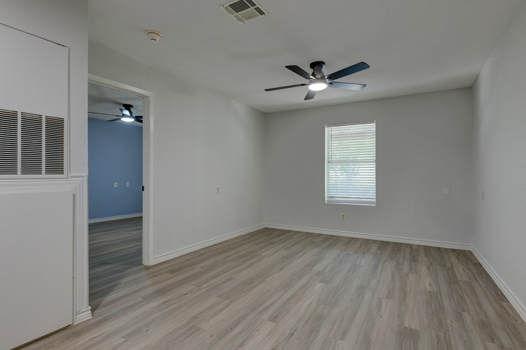 A room with a ceiling fan and light fixture.