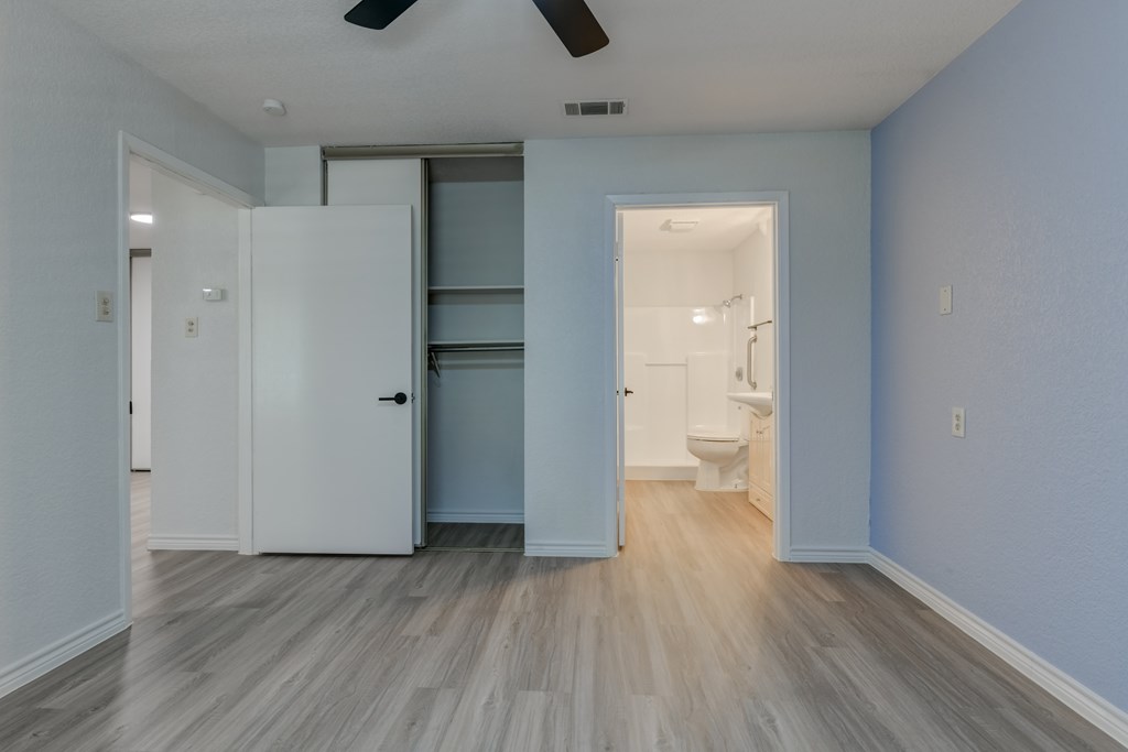A room with a white door and a ceiling fan.