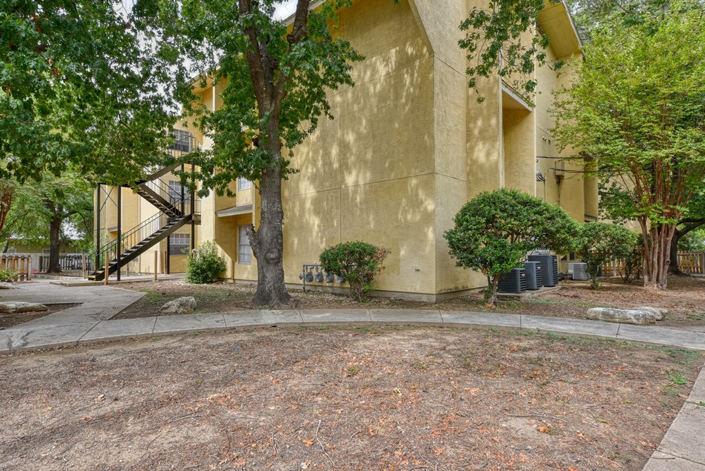 a building with trees and a sidewalk in front of it  at Mayfield Gardens, Texas, 78211