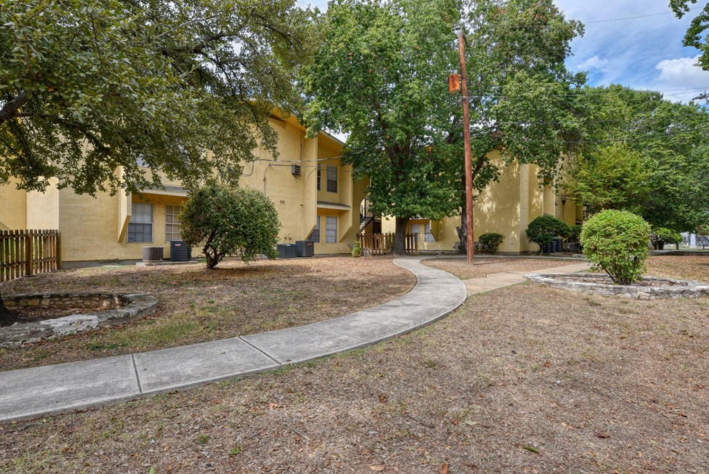 a yellow building with trees and a sidewalk  at Mayfield Gardens, Texas