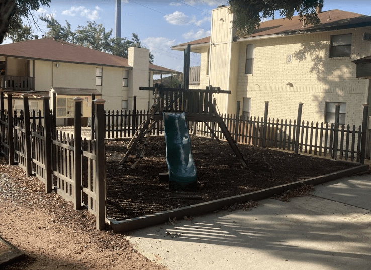 A playground with a green slide and a blue slide.