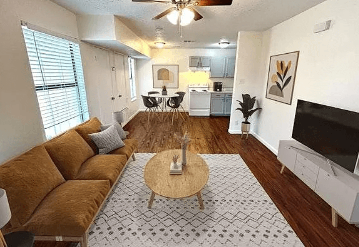 A living room with a brown couch and a coffee table in the middle.