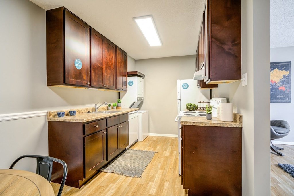 a kitchen with wooden cabinets and a counter top and a sink at Cedar Run Apartments, Memphis, TN, 38115