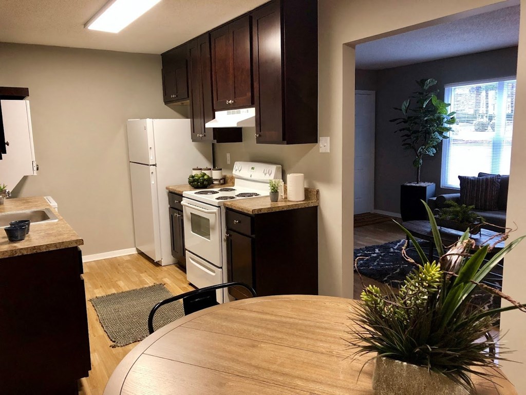 a kitchen with white appliances and a dining table a kitchen with white appliances and a dining table at Cedar Run Apartments, Memphis, TN, 38115