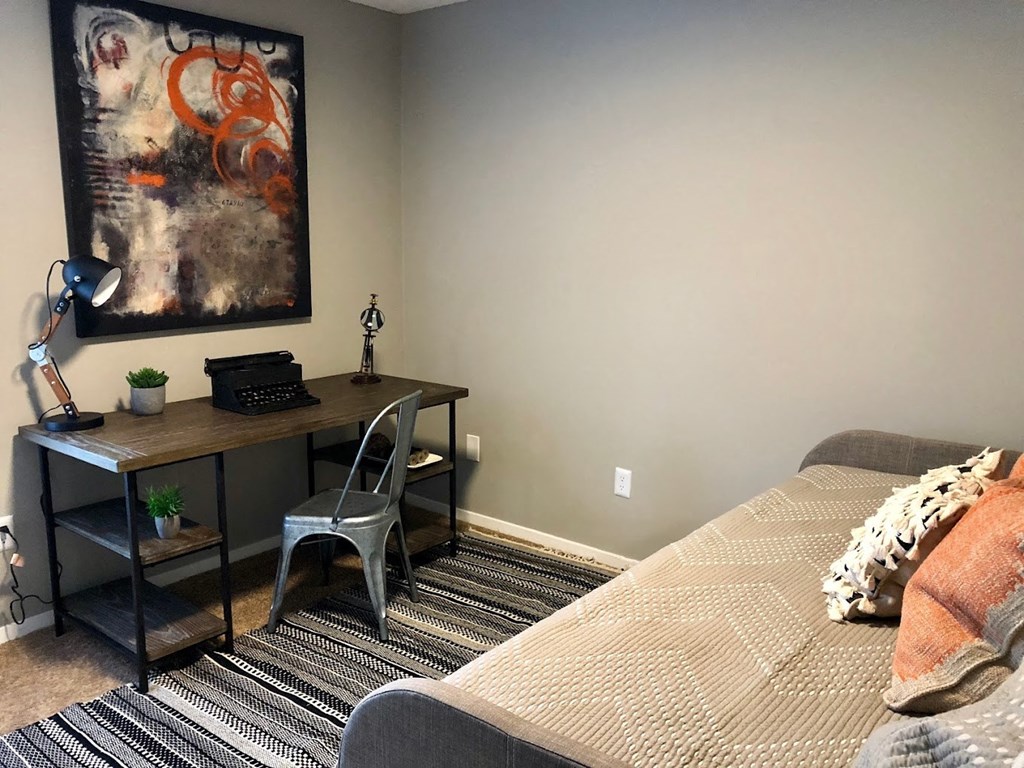 a bedroom with a desk and a bed and a painting a bedroom with a desk and a bed and a painting at Cedar Run Apartments, Memphis, TN