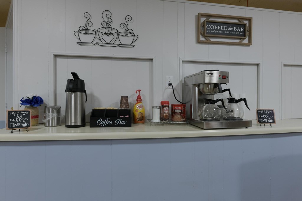 A coffee bar with a coffee maker and a sign that says Coffee Bar.