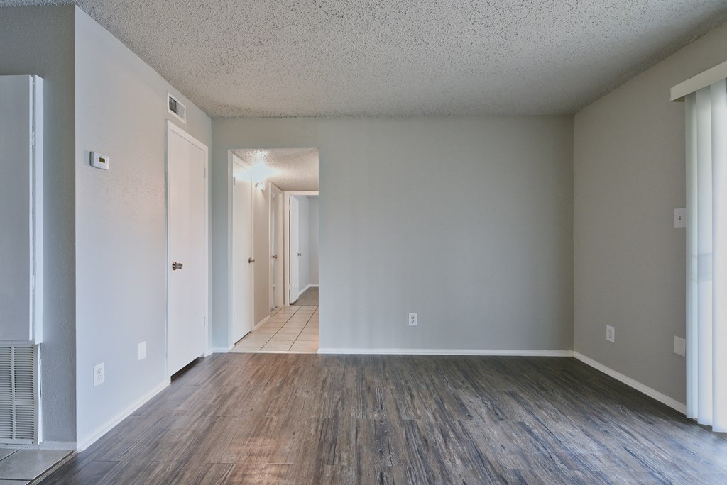 an empty living room with wood floors and white walls at Eagle View Apartments, Pleasanton, TX, 78064