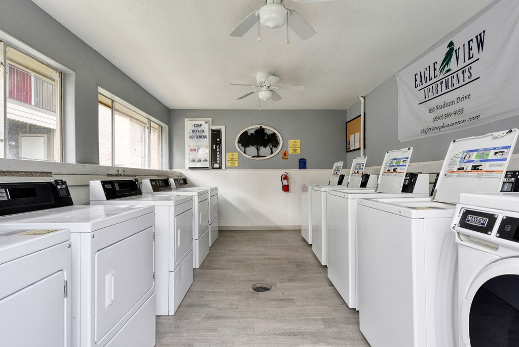 a washer and dryer laundry room with lots of white washers and machines at Eagle View Apartments, Pleasanton