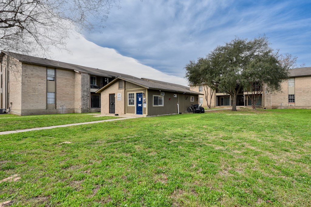 a yard in front of two buildings with a grassy field at Eagle View Apartments, Texas, 78064