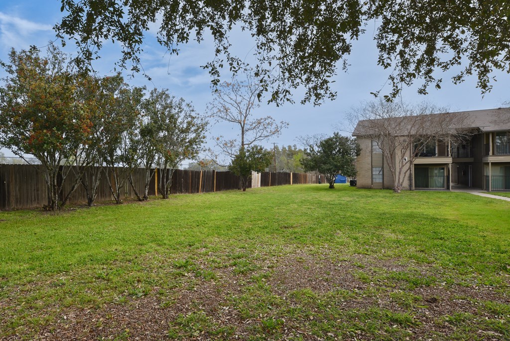 the backyard of a house with a yard and a fence at Eagle View Apartments, Pleasanton, TX