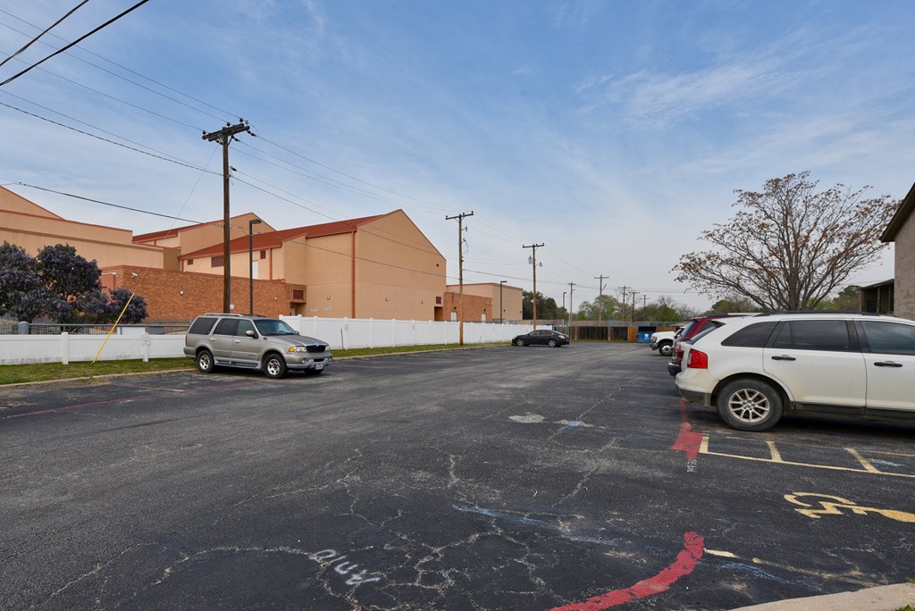 a parking lot in front of a building with cars parked at Eagle View Apartments, Pleasanton, TX