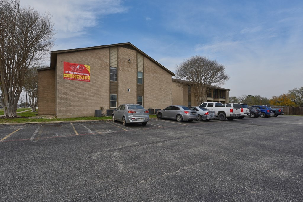 a large brick building with cars parked in front of it at Eagle View Apartments, Pleasanton, TX