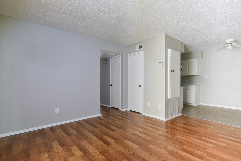 an empty living room with wood flooring and white walls at Eagle View Apartments, Pleasanton, Texas