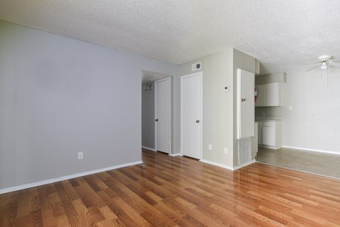 an empty living room with wood flooring and white walls at Eagle View Apartments, Pleasanton, Texas