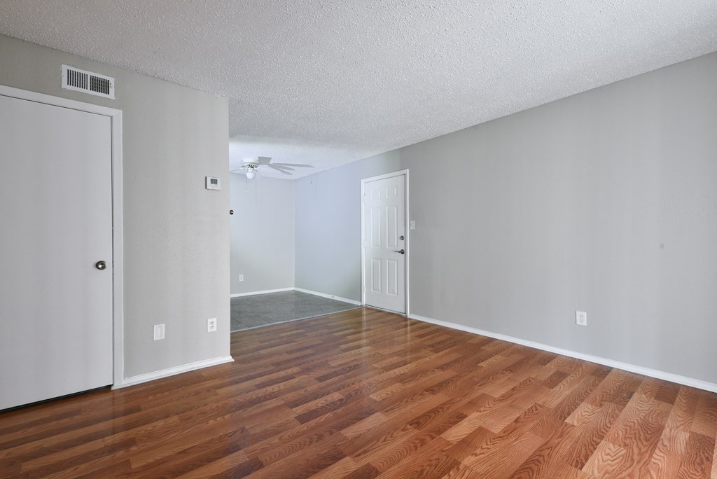 an empty living room with wood flooring and walls at Eagle View Apartments, Pleasanton, TX