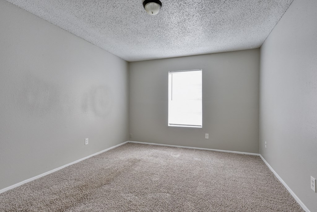 an empty room with carpet and a window at Eagle View Apartments, Pleasanton, TX, 78064