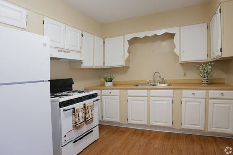 a kitchen with white cabinets and a stove and a refrigerator