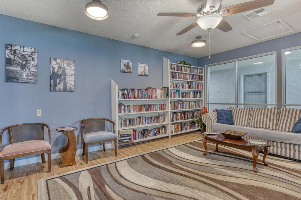A living room with a sofa, chairs, and a bookshelf.