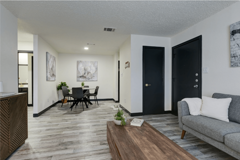 A living room with a grey couch and a wooden coffee table at Ranch at 1856 Apartments, San Marcos, TX, 78666