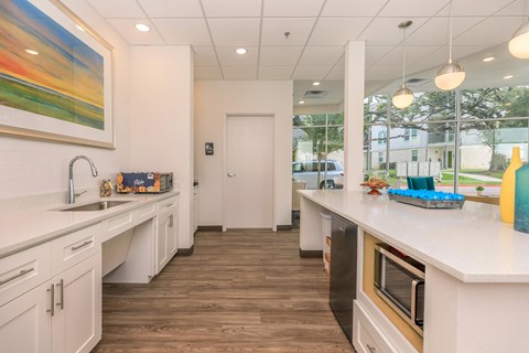 A kitchen with white cabinets and a wooden floor.