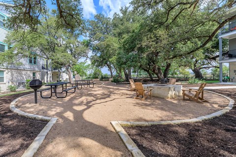 A park with a circular sandy area and benches.
