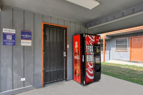a vending machine sits outside of a building at The Crossings at Montrose Apartments, San Antonio, TX