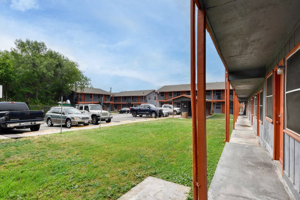 a view of a building with cars parked in a parking lot at The Crossings at Montrose Apartments, Texas