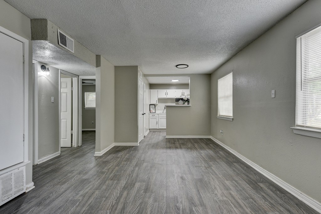 an empty living room and kitchen in a new home at The Crossings at Montrose Apartments, Texas, 78223