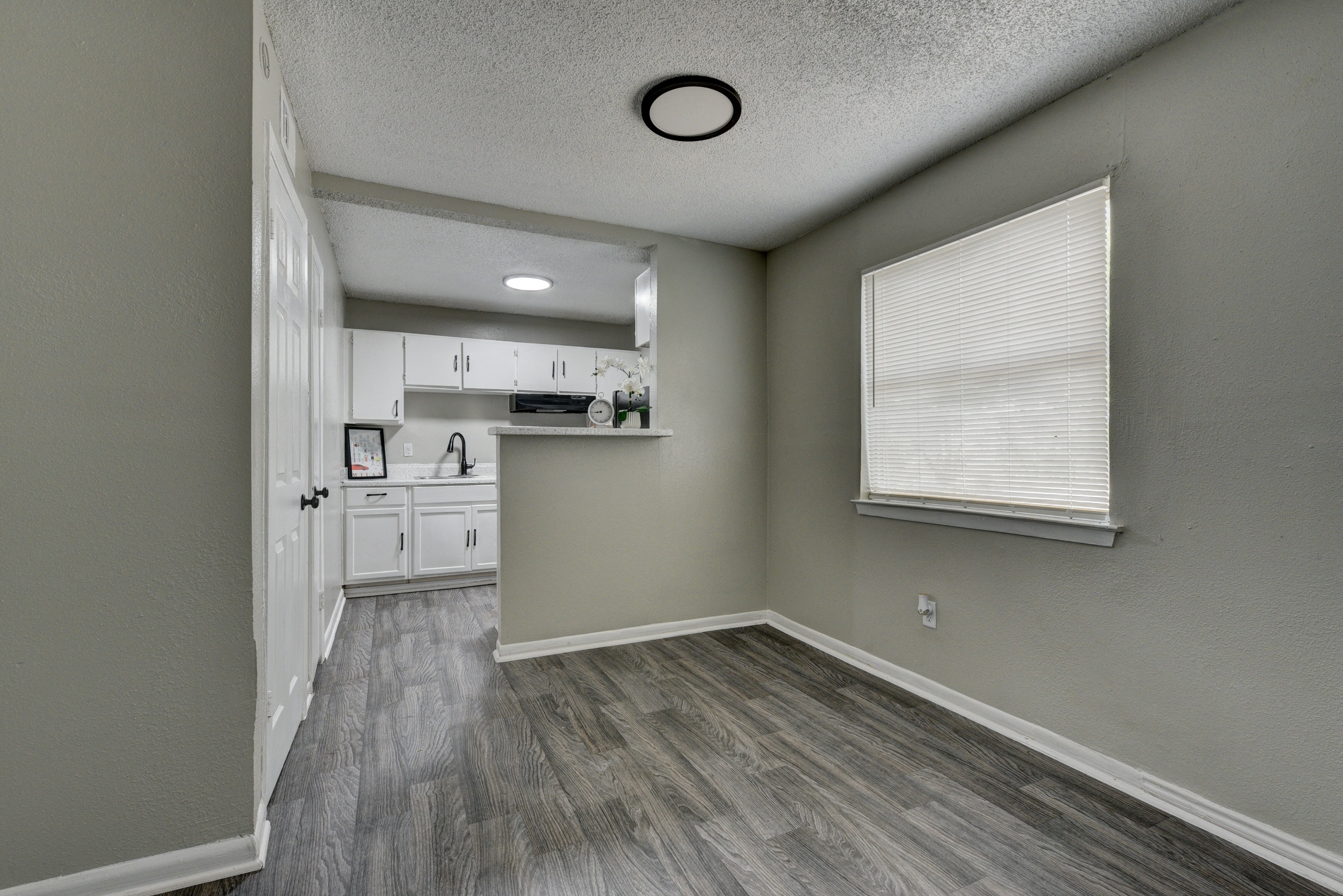 an empty room with a kitchen and a window