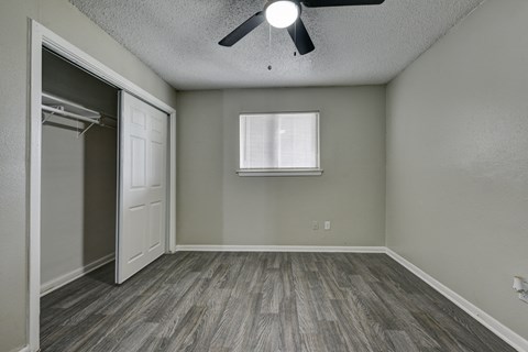 an empty bedroom with a closet and a ceiling fan at The Crossings at Montrose Apartments, San Antonio