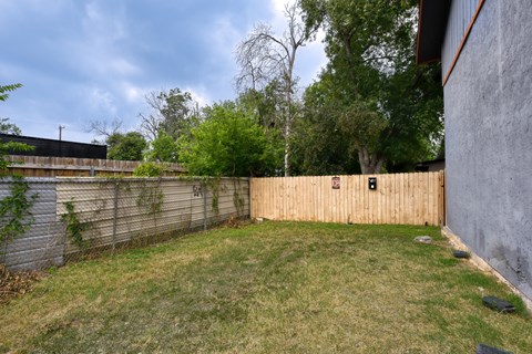 a backyard with a wooden fence and a wooden privacy fence at The Crossings at Montrose Apartments, San Antonio, 78223
