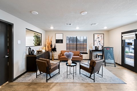 A modern living room with a brown sofa set and a grey rug.