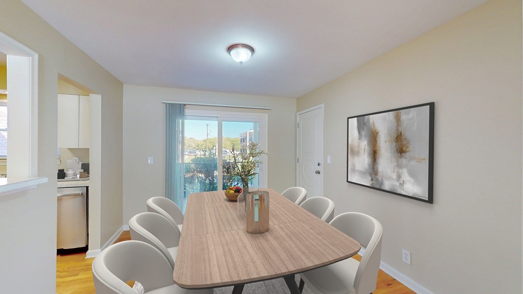A dining room with a table and chairs.