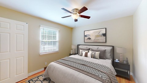 A bedroom with a bed, nightstand, and a ceiling fan.