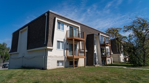 A modern two-story residential building with a balcony on the second floor.