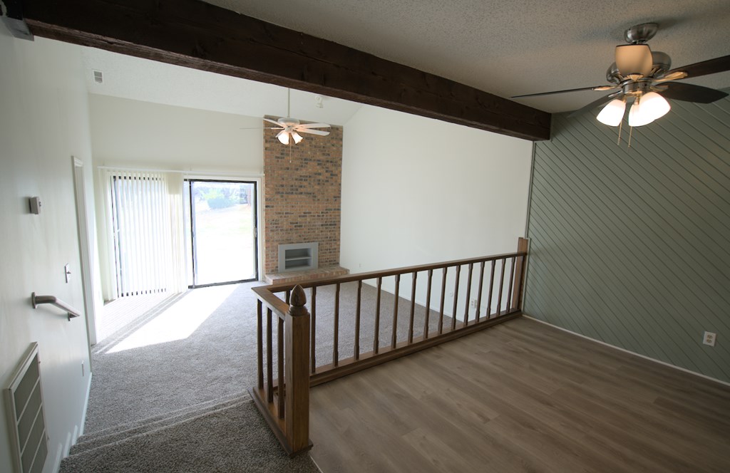 A room with a balcony and a ceiling fan.