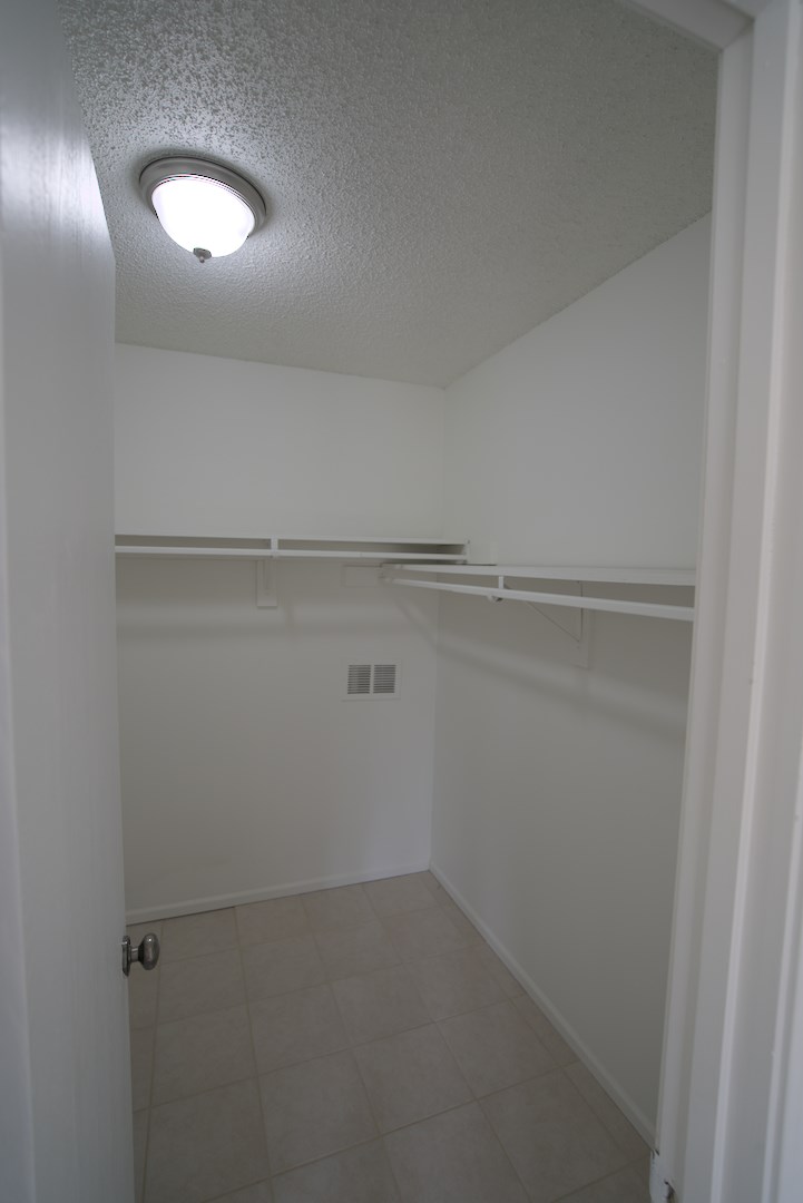 A white closet with a light on the ceiling.
