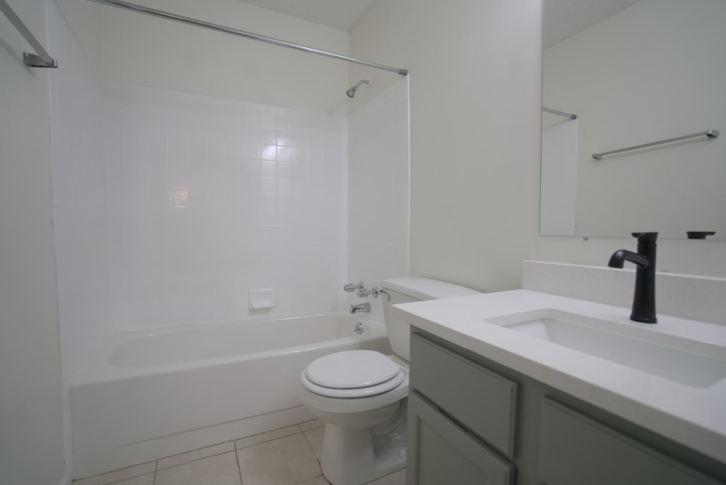 A white toilet sits next to a white sink in a bathroom.