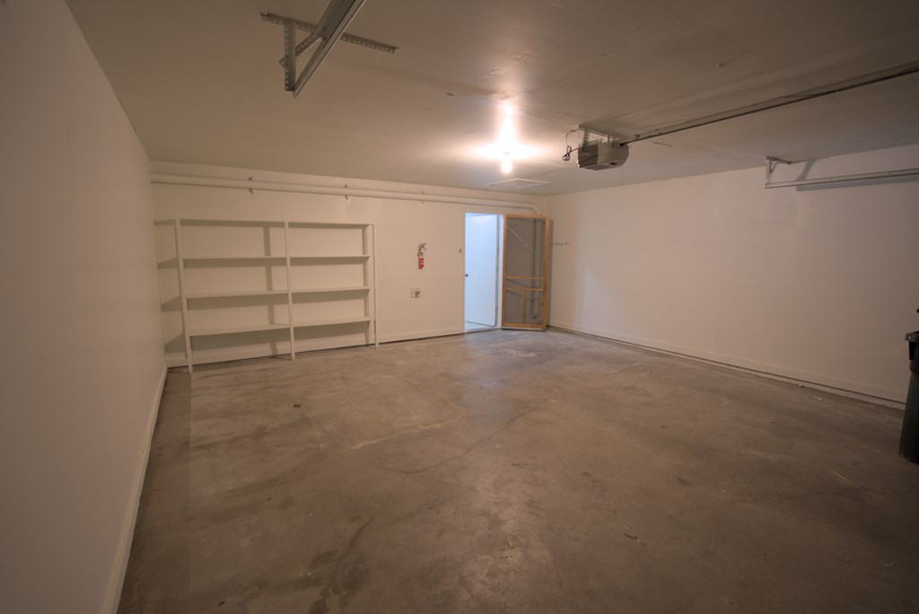 A large empty room with a door and a window.