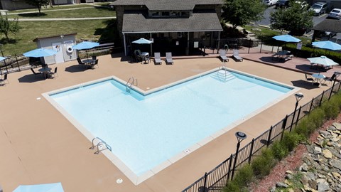 A large outdoor swimming pool surrounded by a black fence.